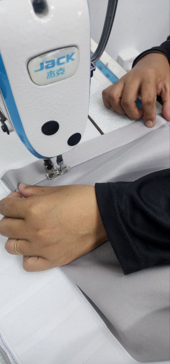 A person sewing curtains to fulfill a client's order